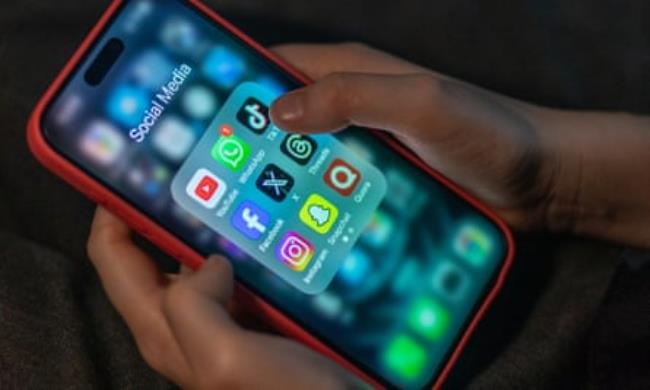 hands hold iPhone displaying multiple social media apps
